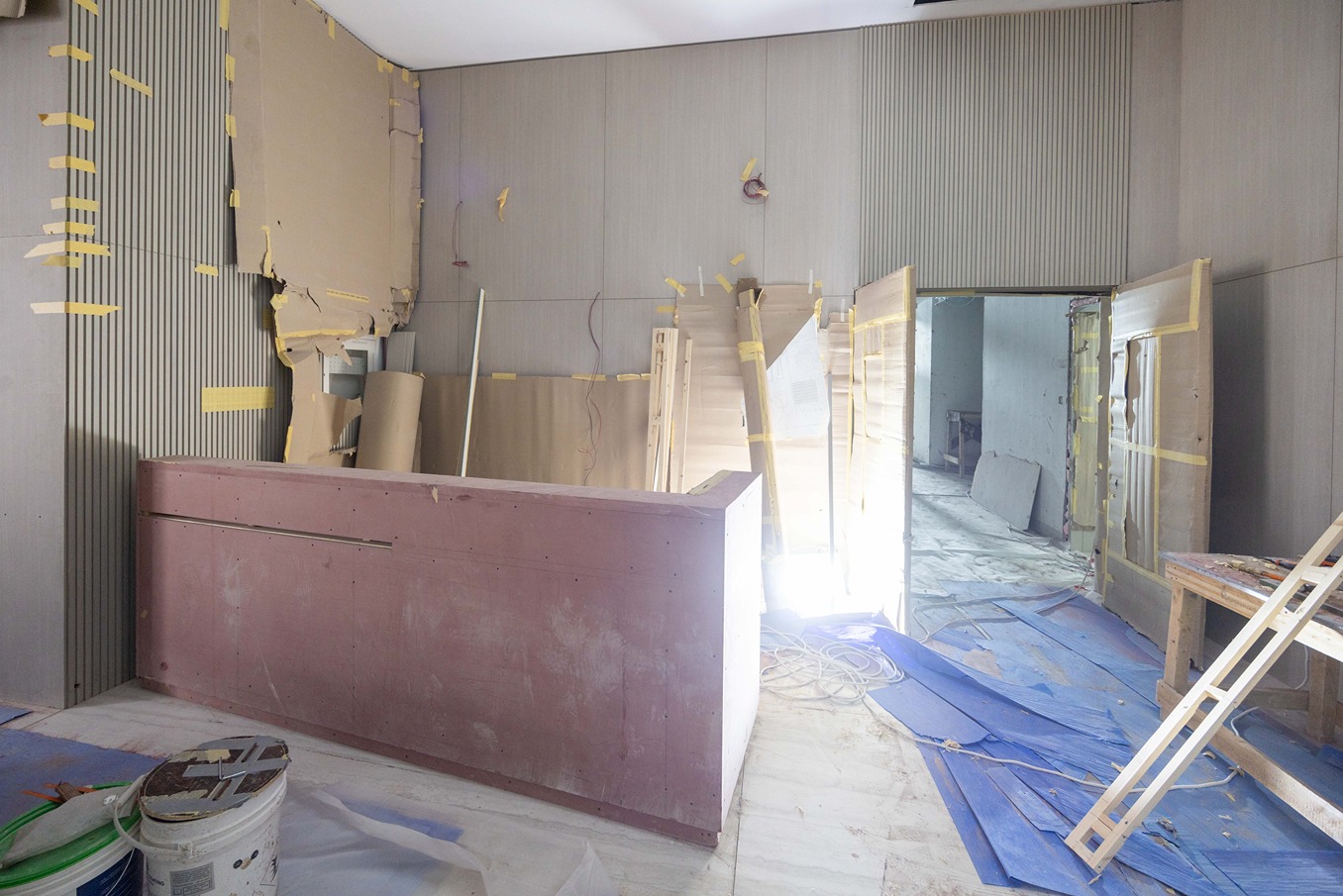 Pearl House By Imtiaz An under-construction room featuring a pink counter, exposed walls, and various building materials scattered on the floor.